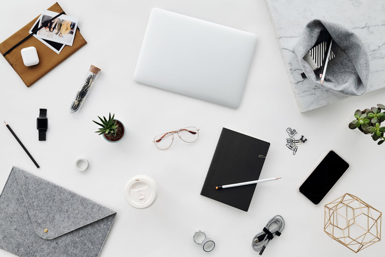 Aesthetic top-down view of office essentials on a clean white surface, perfect for creative inspiration.